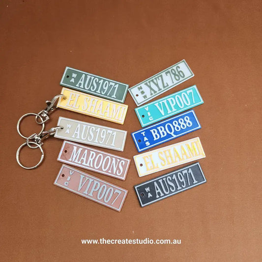 Assorted personalized keychains displayed on a brown background, featuring unique designs and vibrant colors.