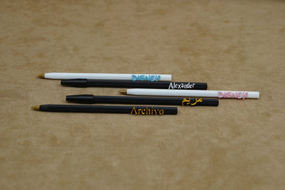 Personalised pens featuring names like Alexander and Archivo on a soft surface, showcasing unique writing experiences.