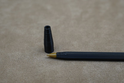 Personalised pen with removable cap, featuring a black body and gold tip on a neutral background.