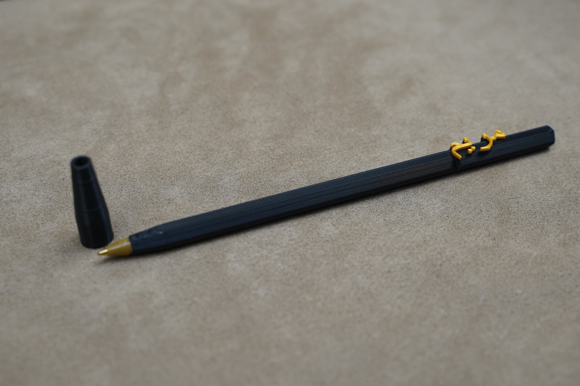 Personalised pen on a beige surface, featuring a unique design and a removable cap for a customized writing experience.