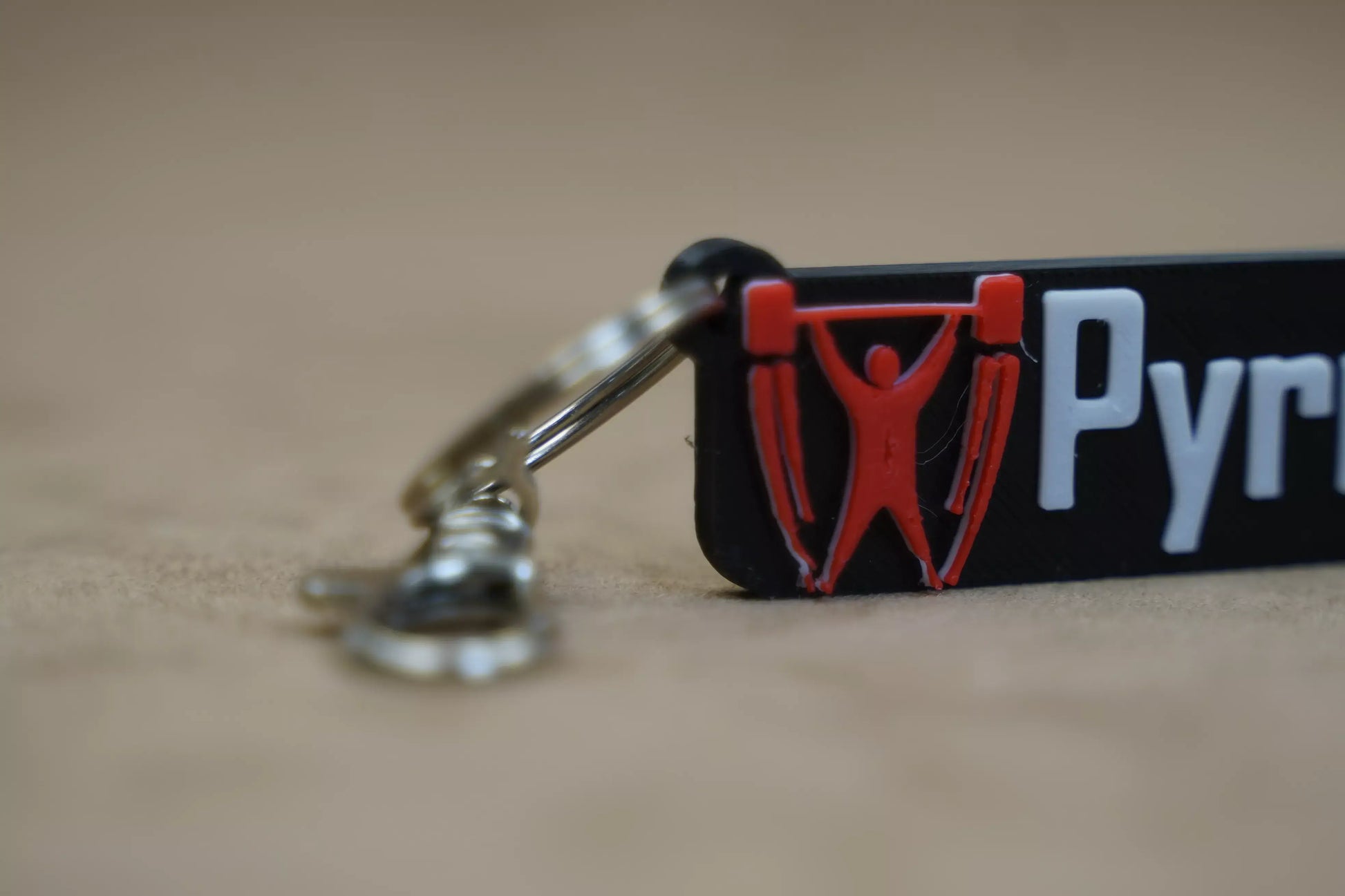 Close-up of a personalised weightlifting keychain featuring a barbell and silhouette, perfect for fitness enthusiasts.