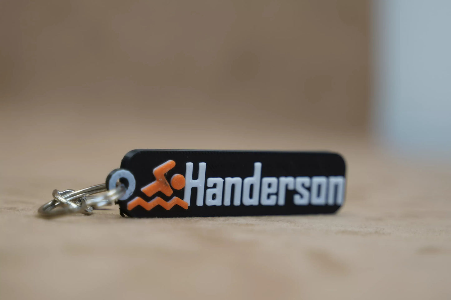 Personalised swimmer keychain featuring the name "Handerson" with swimming icon design in vibrant colors.