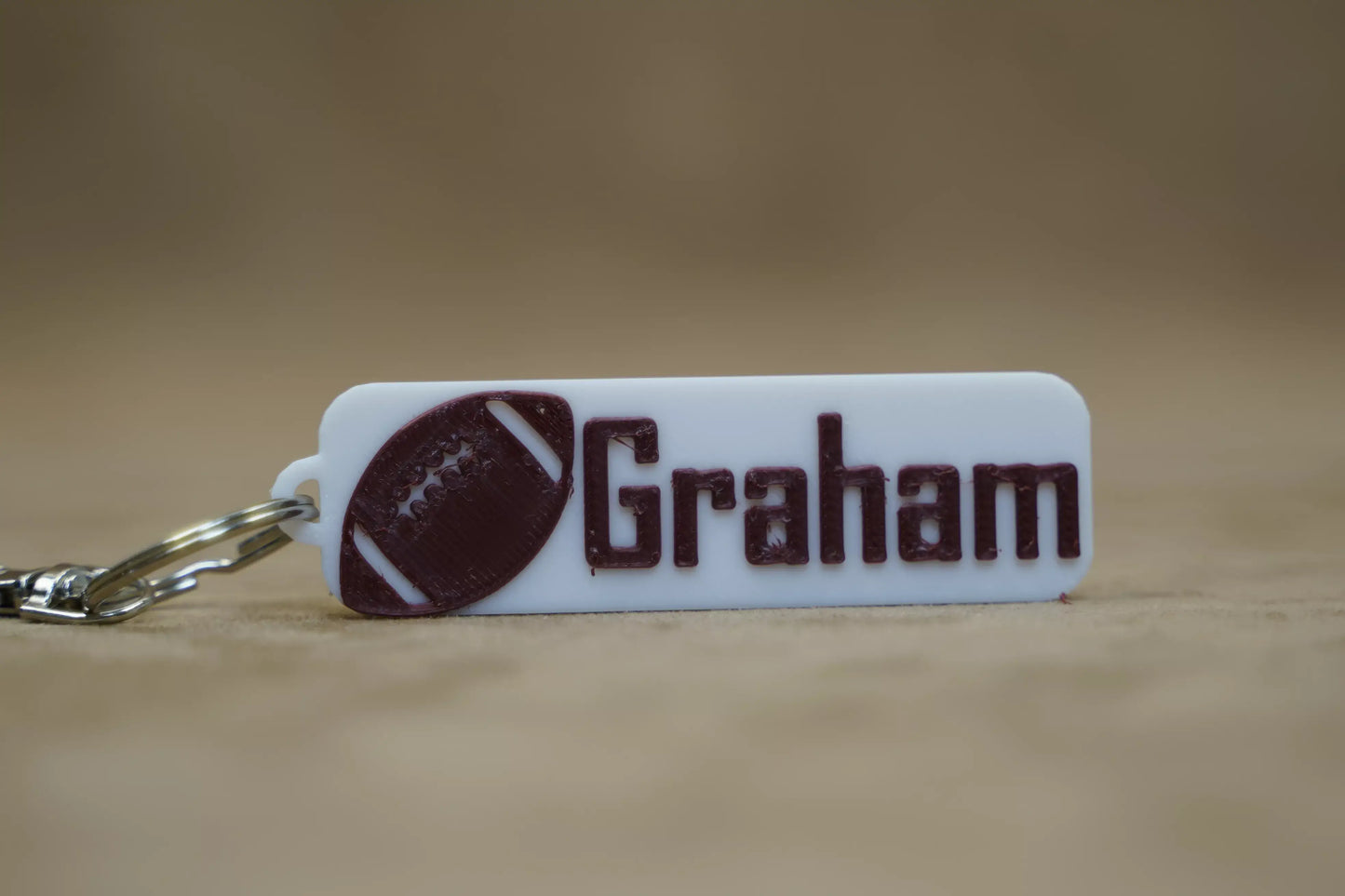 Personalised footy keychain featuring the name "Graham" and a football design, perfect for footy fans.