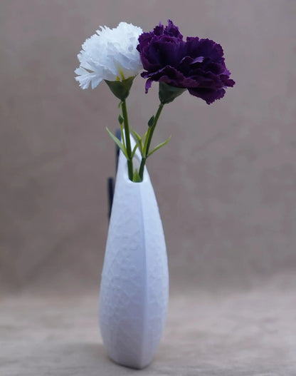 Elegant white vase holding purple and white flowers, perfect for home decor and table settings.