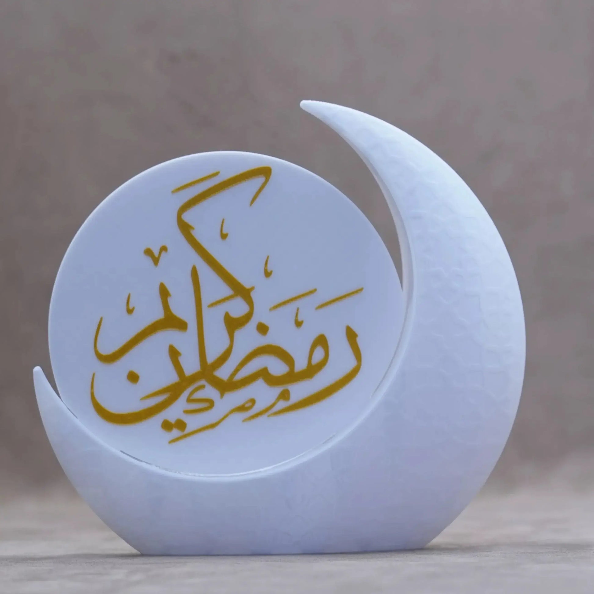 Elegant Ramadan Decor in white crescent shape with gold script, perfect for festive table settings.