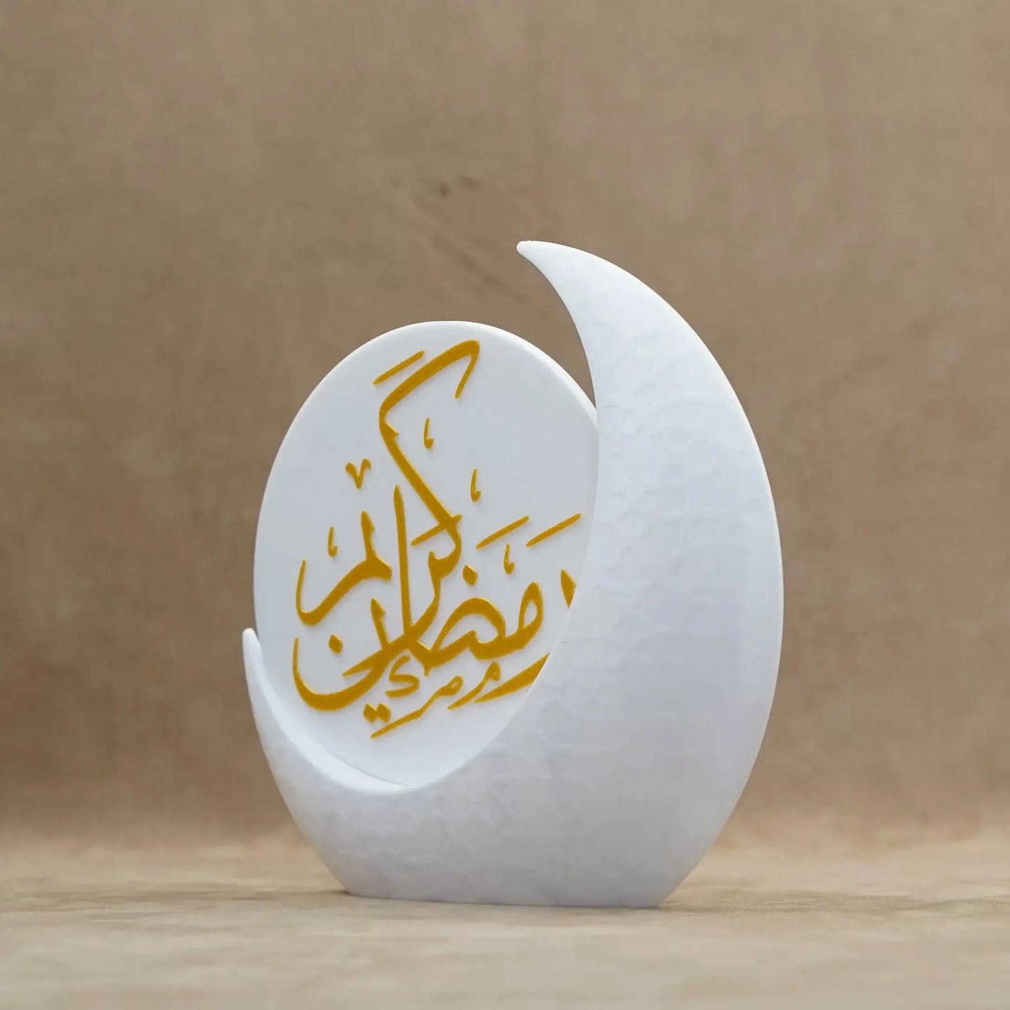 Elegant Ramadan decor piece with golden calligraphy on a white crescent moon base, perfect for festive table settings.