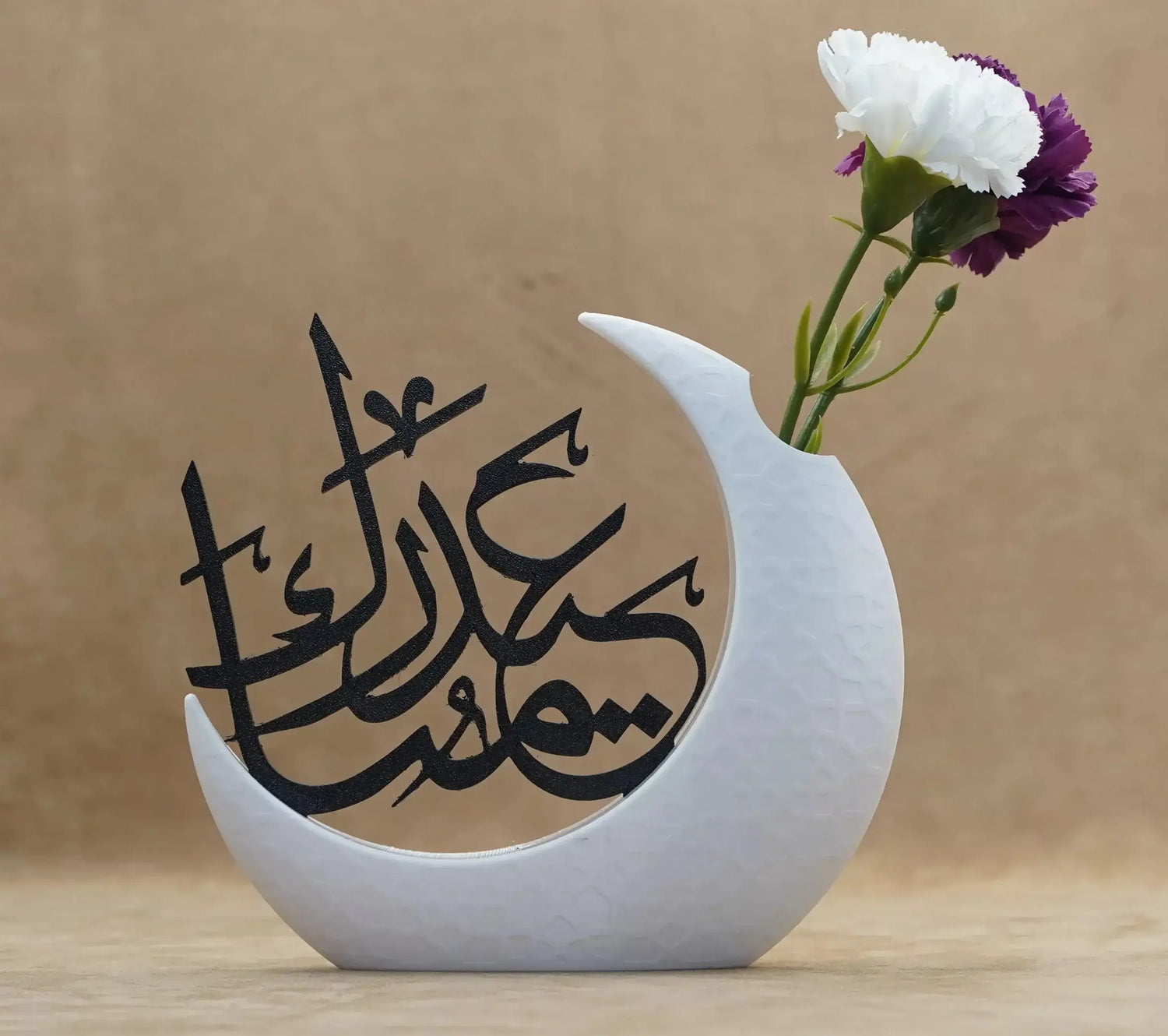 Elegant moon-shaped vase with Arabic script for Ramadan decor, featuring a floral arrangement for festive table setting.