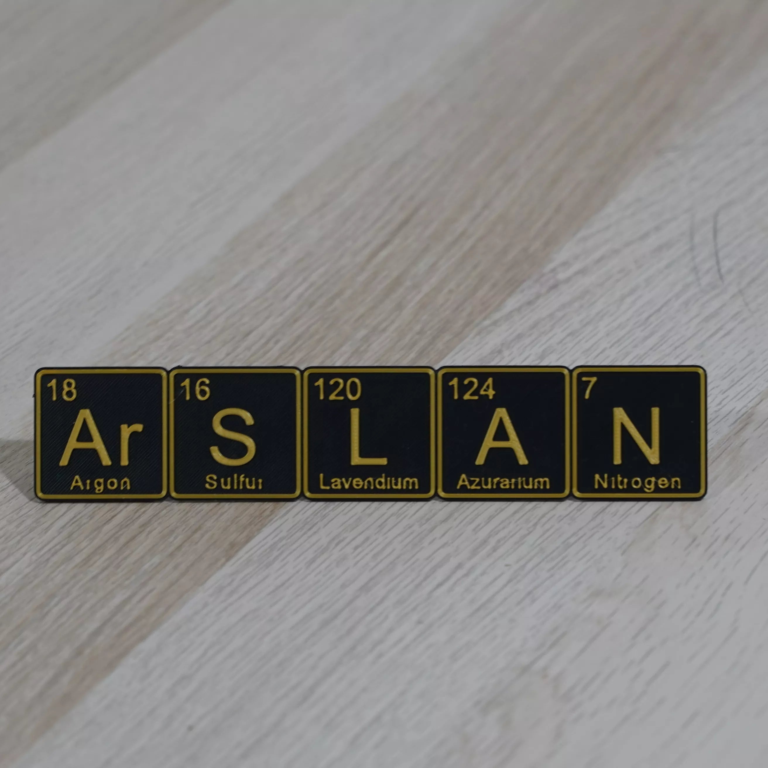 Personalized periodic table name plate featuring elements Ar, S, L, A, N styled as a desk display.